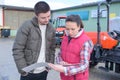 Saleswoman convincing young famrer to buy new agricultural machinery Royalty Free Stock Photo