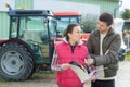 Saleswoman convincing young famrer to buy new agricultural machinery Royalty Free Stock Photo