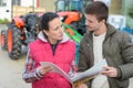 saleswoman convincing young famrer to buy new agricultural machinery Royalty Free Stock Photo