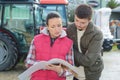 saleswoman convincing young famrer to buy new agricultural machinery Royalty Free Stock Photo