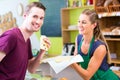 Saleswoman at counter offering cheese