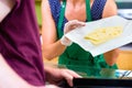 Saleswoman at counter offering cheese