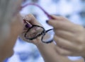 The saleswoman with French-style decorated nails tries out the glasses to the customer. Two people females