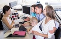 saleswoman in furniture store helping young family in choice of mattress material