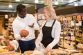 Saleswoman helping man to choose bulk products