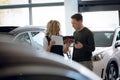 Saleswoman holding brochure while standing with customer