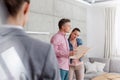 Saleswoman looking at couple standing with document at home