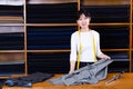 Saleswoman offering cloth in textile shop