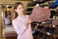 Saleswoman offering hats in headwear shop