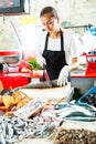 Saleswoman processing fish for sale