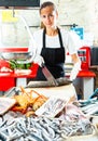 Saleswoman processing fish for sale