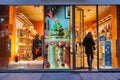 Saleswoman seting up Christmas tree in a gift shop wearing protective mask