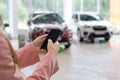 Saleswoman using mobile smart phone at dealer showroom. Modern working process. Royalty Free Stock Photo