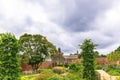 Walled garden with flower beds and mature trees. Royalty Free Stock Photo