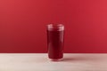 Salgam - popular Turkish drink, made from fermented purple carrots, turnips or beets. Glass on red background with copy space