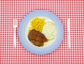 Salisbury steak dinner on red checkerboard cloth