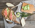 Salmon, avocado and thyme sandwiches in baguette tied up with decoration rope on a rustic wooden board over rough wood background