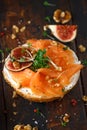 Salmon Bagel Sandwich with figs, cress salad, walnuts, cream cheese and grain on rustic wooden background. healthy Royalty Free Stock Photo