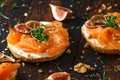 Salmon Bagel Sandwich with figs, cress salad, walnuts, cream cheese and grain on rustic wooden background. healthy Royalty Free Stock Photo