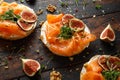 Salmon Bagel Sandwich with figs, cress salad, walnuts, cream cheese and grain on rustic wooden background. healthy Royalty Free Stock Photo