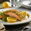 Salmon baked with pistachio crust served on a plate with watercress and lemon slices. Festive table setting