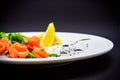 Salted salmon with garnish on black background