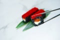 Salmon Black rice Sushi roll with cattle fish inks in chopsticks. Roll pieces with red flying fish roe Tobiko on top