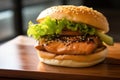 Salmon burger, with a grilled salmon fillet, teriyaki sauce, lettuce, cucumber, and wasabi mayo on a brioche bun with Royalty Free Stock Photo