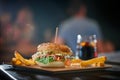 Salmon burger with french fries on a pub background. Copy space