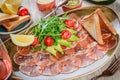 Salmon Carpaccio with Rocket Salad, avocado, tomatoes, lemon on light wooden background Royalty Free Stock Photo