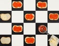 Salmon caviar canapes, butter, red caviar in a jar on chess board, top view Royalty Free Stock Photo