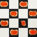 Salmon caviar canapes pattern on chess bords, top view Royalty Free Stock Photo