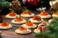 Salmon caviar and soft cheese savory crackers with decoration, gifts, green tree branch on wooden rustic table.