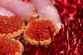 Salmon caviar in a tartlet on a glass dish. Festive table setting