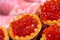 Salmon caviar in a tartlet on a glass dish. Festive table setting