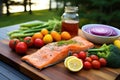 salmon on a cedar plank alongside fresh vegetables ready for grilling Royalty Free Stock Photo