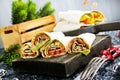 Salmon and cream cheese wraps. Rolls with smoked salmon, basil and rocket salad. Burrito on serving board Royalty Free Stock Photo