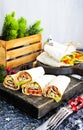 Salmon and cream cheese wraps. Rolls with smoked salmon, basil and rocket salad. Burrito on serving board Royalty Free Stock Photo