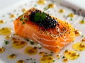 A salmon dish with black caviar on a white plate