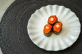 Salmon eggs or Ikura in Japanese style sushi fresh from raw salmond fish served on a white plate on dark background Royalty Free Stock Photo