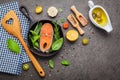 Salmon filet in old cast iron skille on dark stone background. Ingredients for making steak concept with copy space . Various Royalty Free Stock Photo