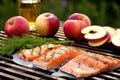 salmon fillet, apple quarters and bbq grill in the backdrop