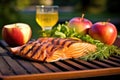 salmon fillet, apple quarters and bbq grill in the backdrop