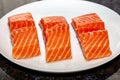 Salmon Fillet. Slices of fresh raw salmon fish on white plate on dark background i Royalty Free Stock Photo