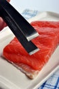 Salmon fillet and a tongs Royalty Free Stock Photo