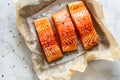 Salmon fillets on parchment paper with sesame seeds