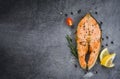 Salmon fish fillet steak seafood / Grilled salmon steak with herbs and spices rosemary lemon on dark background Royalty Free Stock Photo