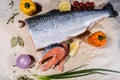 Salmon fish is a large piece and cut into pieces around vegetables pepper onions and lemon fruit. View from above Royalty Free Stock Photo