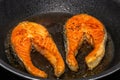 Salmon fish steaks fried in a frying pan Royalty Free Stock Photo