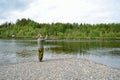 Salmon fisherman cleaning lure hooks for river bottom debris